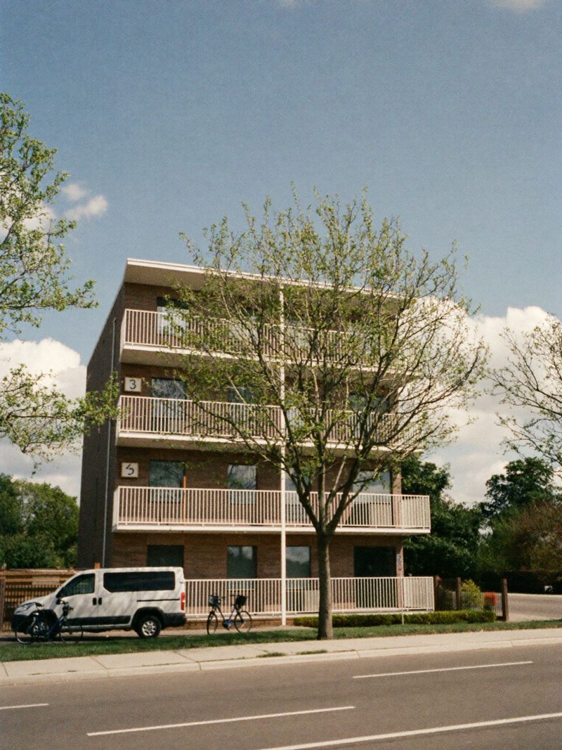 Modernes Backstein-Wohnhaus mit Balkonen in einer ruhigen Straße